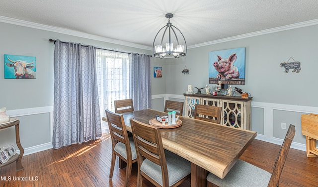 dining space with a textured ceiling, crown molding, an inviting chandelier, and hardwood / wood-style floors