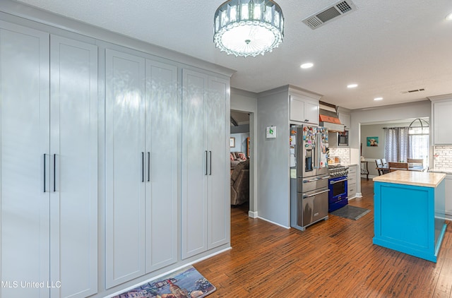 kitchen featuring visible vents, dark wood-type flooring, stainless steel appliances, and light countertops