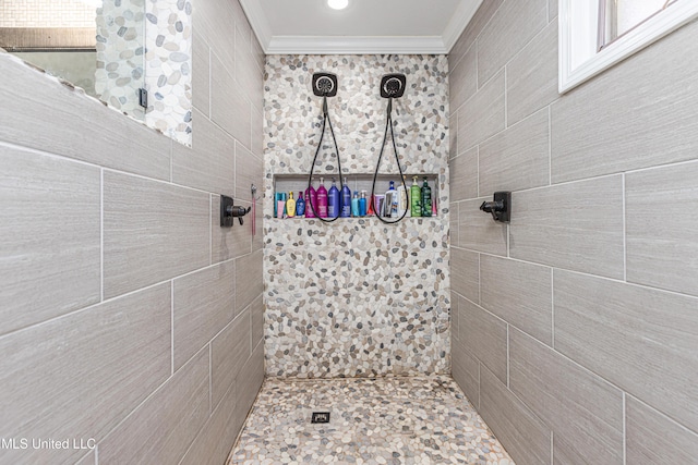 bathroom with crown molding and a tile shower