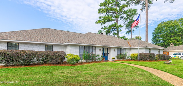 single story home featuring brick siding, a front lawn, and a shingled roof