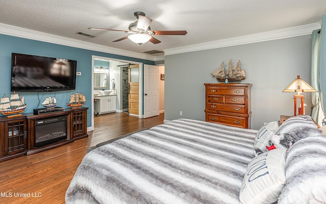 bedroom featuring visible vents, a textured ceiling, wood finished floors, crown molding, and ceiling fan