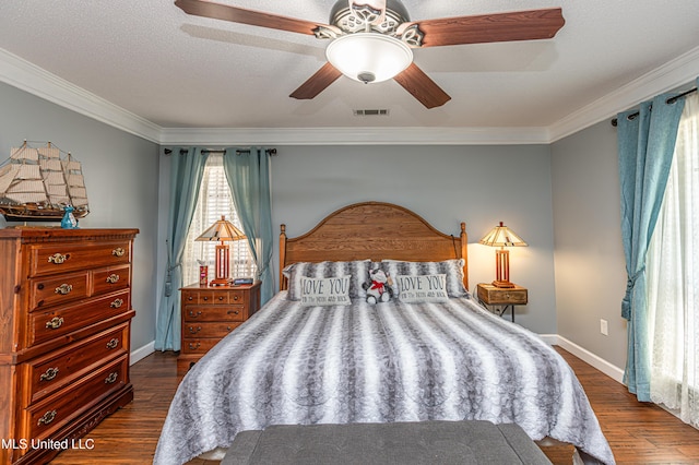 bedroom with dark wood finished floors, visible vents, and crown molding