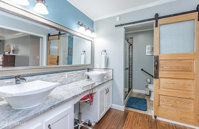 bathroom featuring decorative backsplash, crown molding, a shower stall, and a sink