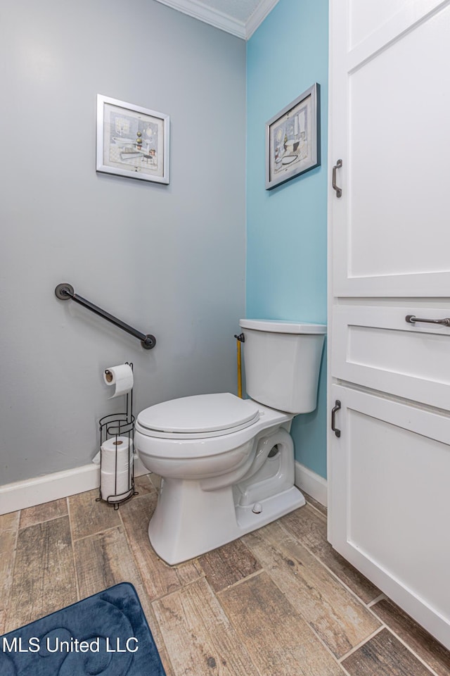 half bath featuring ornamental molding, toilet, baseboards, and wood tiled floor