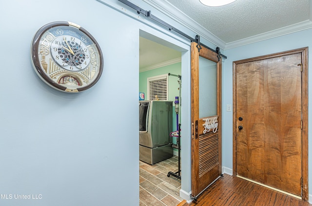 corridor with a textured ceiling, a barn door, wood finished floors, and ornamental molding