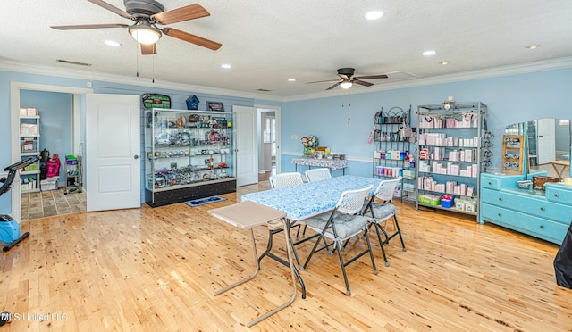 dining area with wood finished floors, ornamental molding, and a ceiling fan