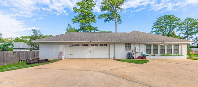 ranch-style house featuring fence, driveway, roof with shingles, a garage, and brick siding