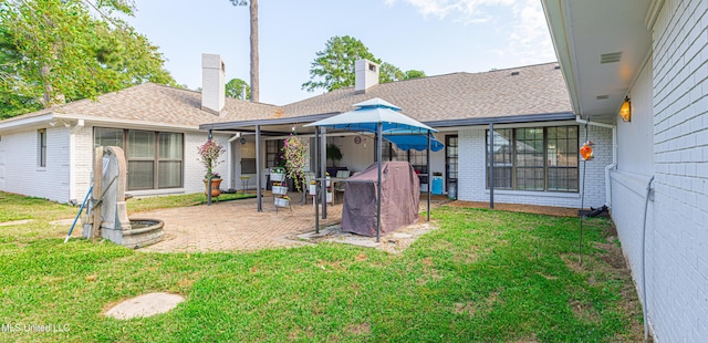 rear view of property with a patio area, brick siding, roof with shingles, and a lawn