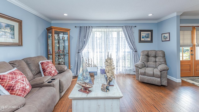 living room with baseboards, a healthy amount of sunlight, hardwood / wood-style floors, and crown molding