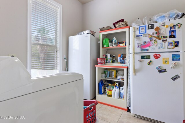 clothes washing area featuring light tile patterned floors