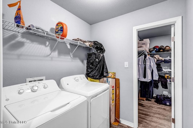 laundry room with laundry area, wood finished floors, and washing machine and dryer