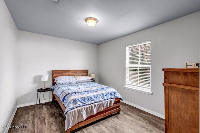 bedroom with baseboards and wood finished floors