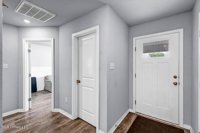 entryway featuring visible vents, baseboards, and wood finished floors