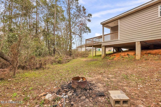 view of yard with an outdoor fire pit and a deck