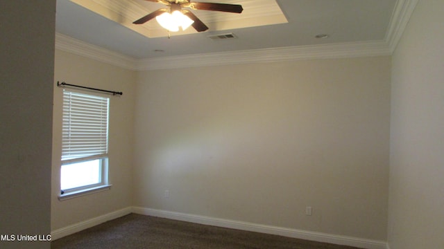 unfurnished room with ornamental molding and a raised ceiling