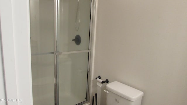 full bathroom featuring toilet and a stall shower