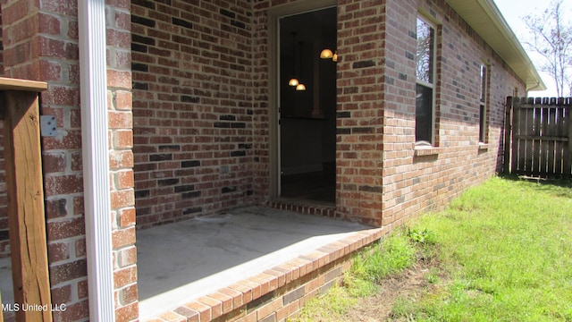 doorway to property with fence and brick siding