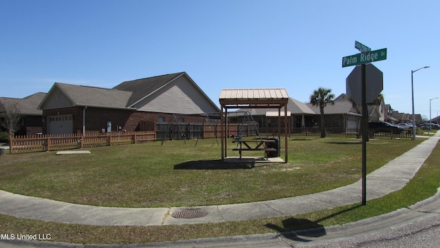 surrounding community with a garage, fence, and a lawn