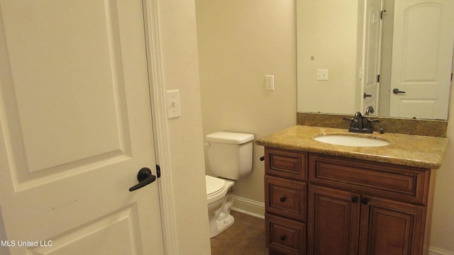 bathroom with tile patterned flooring, vanity, and toilet