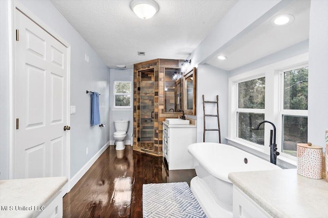 full bathroom featuring a textured ceiling, vanity, hardwood / wood-style flooring, and independent shower and bath