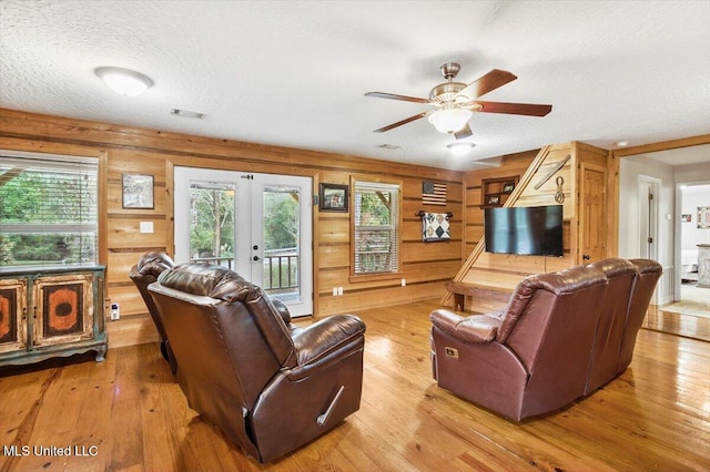 living room with light wood-type flooring, plenty of natural light, a textured ceiling, and ceiling fan