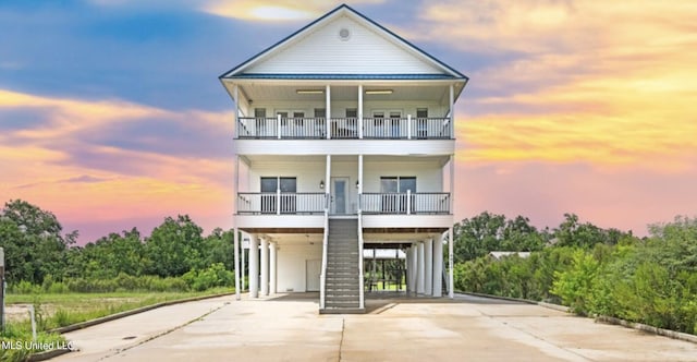 beach home featuring a balcony and a carport