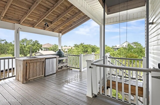 wooden deck with sink, an outdoor kitchen, and grilling area