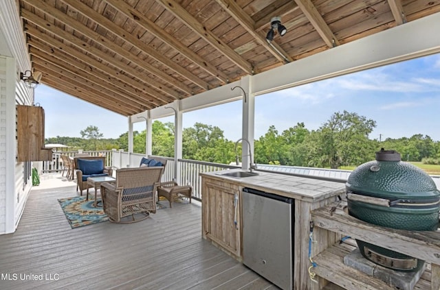 wooden terrace featuring area for grilling and sink