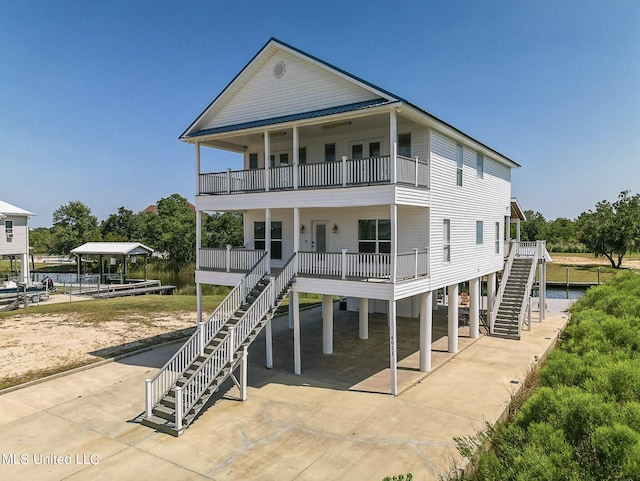 4011 S Nassau St, Bay Saint Louis, MS 39520 - view of front of house with stairway, driveway, a balcony, a carport, and covered porch