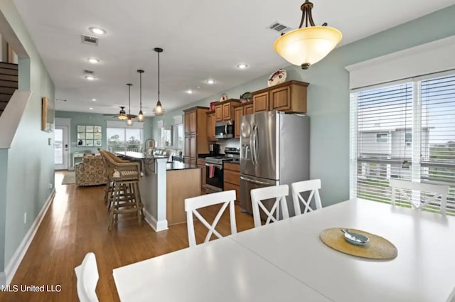 dining space with ceiling fan and dark hardwood / wood-style flooring