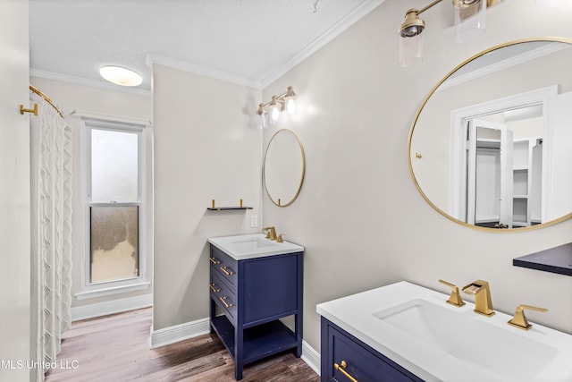 bathroom with baseboards, ornamental molding, a sink, and wood finished floors