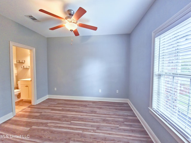 64 Oak Alley Ln, Long Beach, MS 39560 - unfurnished bedroom featuring multiple windows, ensuite bath, wood finished floors, and visible vents