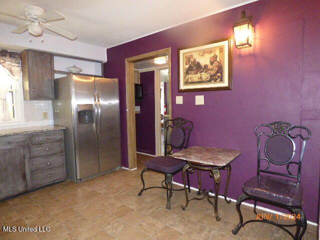 kitchen featuring ceiling fan, stainless steel refrigerator with ice dispenser, and decorative backsplash