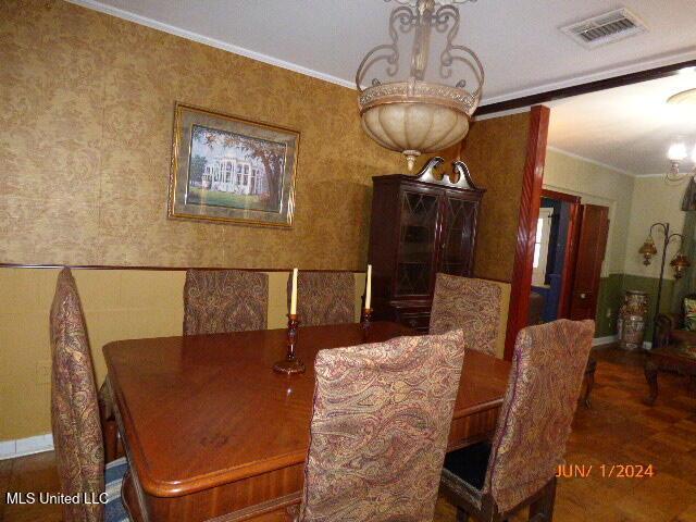 dining area featuring an inviting chandelier and crown molding