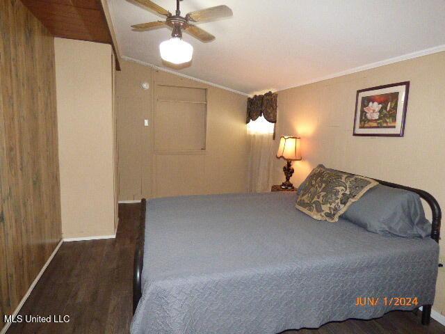 bedroom featuring lofted ceiling, ornamental molding, ceiling fan, and dark hardwood / wood-style floors