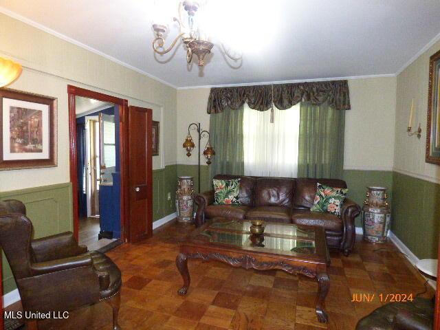 living room with an inviting chandelier and crown molding