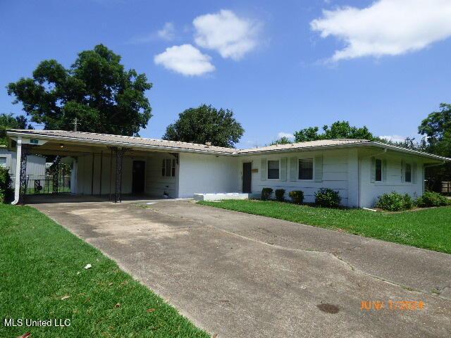 single story home with a front lawn and a carport