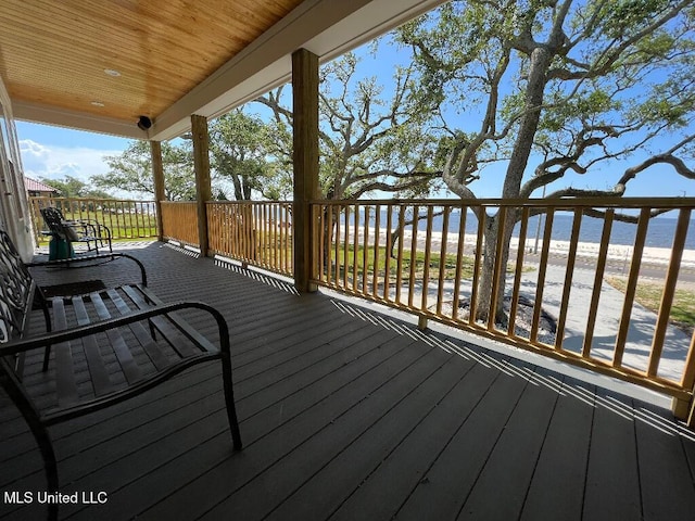 deck featuring a view of the beach and a water view