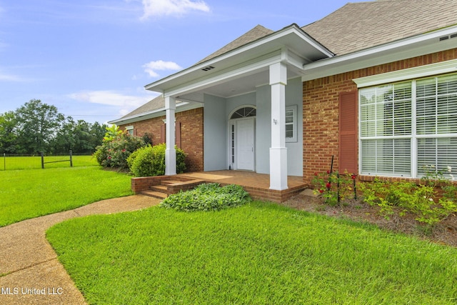 380 Green Acres Dr, Canton, MS 39046 - property entrance featuring brick siding, a shingled roof, a lawn, and covered porch