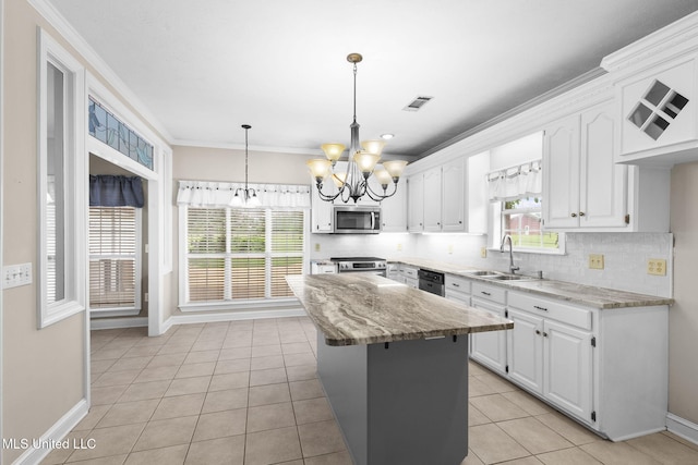 380 Green Acres Dr, Canton, MS 39046 - kitchen with appliances with stainless steel finishes, a chandelier, white cabinetry, tasteful backsplash, and crown molding