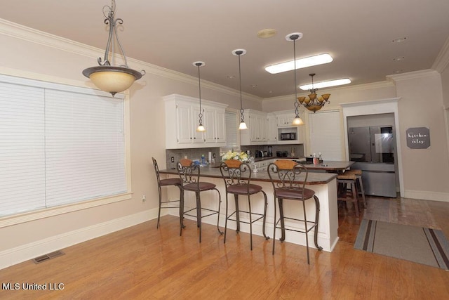 kitchen with smart refrigerator, built in microwave, wood finished floors, dark countertops, and a kitchen bar