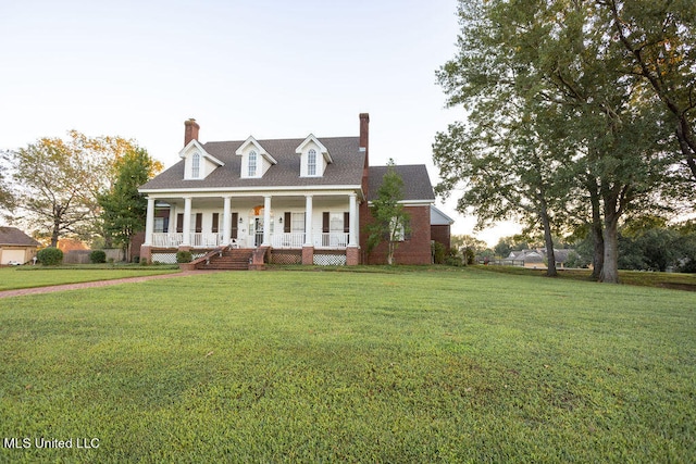 cape cod-style house featuring a front lawn and covered porch