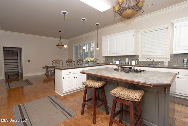 kitchen with a kitchen island, white cabinets, and wood-type flooring