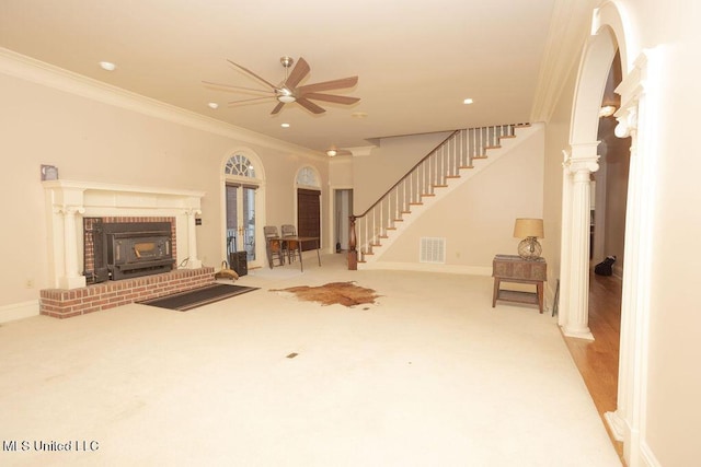 unfurnished living room featuring ceiling fan, crown molding, stairs, carpet flooring, and baseboards