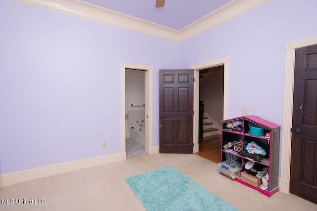 carpeted bedroom featuring crown molding, connected bathroom, and a ceiling fan