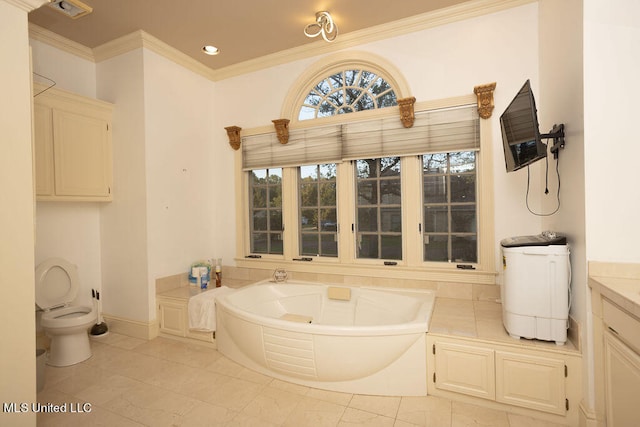 bathroom featuring a tub, toilet, vanity, ornamental molding, and tile patterned flooring