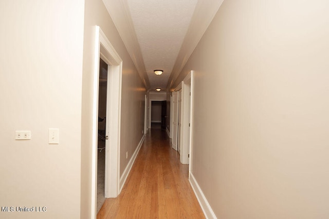 corridor with light hardwood / wood-style floors