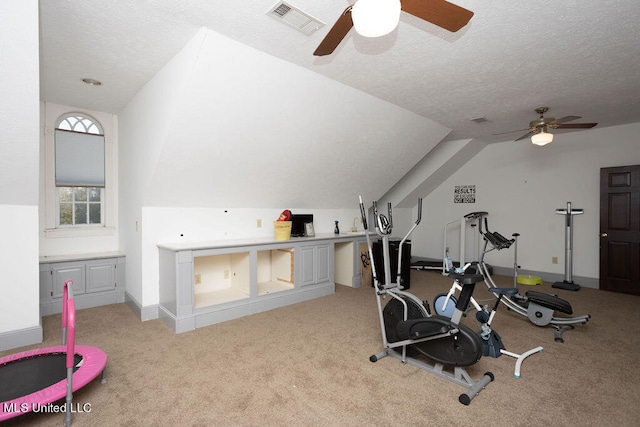 exercise room with vaulted ceiling, light carpet, a textured ceiling, and ceiling fan