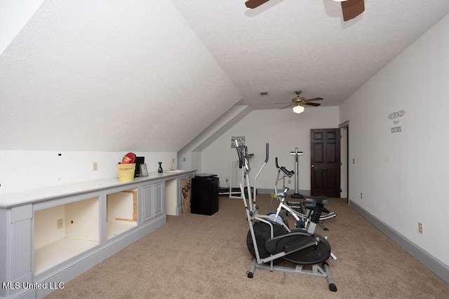 exercise area featuring lofted ceiling, a textured ceiling, light colored carpet, and ceiling fan