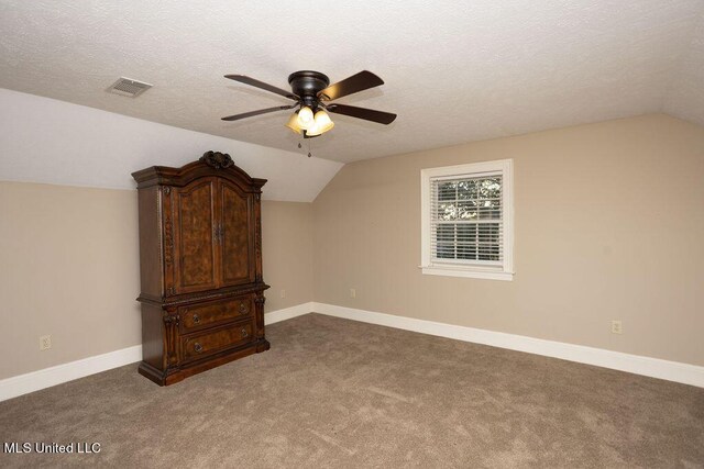 bonus room featuring vaulted ceiling, a ceiling fan, carpet floors, a textured ceiling, and baseboards